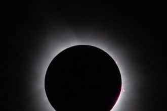 Eclissi solare totale con la luna davanti al sole e la corona visibile intorno al disco